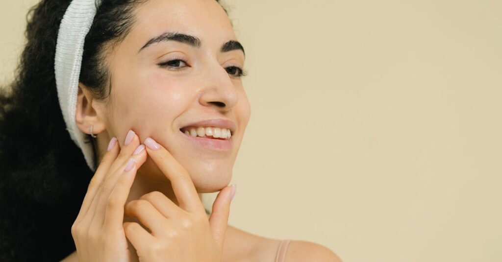 Close-up of a smiling woman applying skin treatment, promoting natural beauty and skincare.